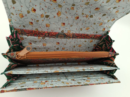 Uvnitř jsou přihrádky na karty, zipová kapsa na mince a přepážky pro papírové peníze. 